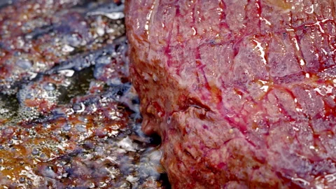 Beef steak. Super close-up of a juicy rare beef steak cooking in a cast iron pan Stock Footage 315904265