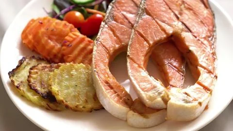 Beef steak with vegetables served on a white plate Stock Photos
