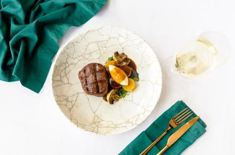Beef steak on a white plate with a glass of wine Stock Photos