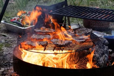 Beef Steaks on a Grill with Flames Stock Photos