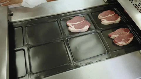 Beef Steaks Placed by Hand into Black Plastic Packaging Trays Stock Footage 341308675