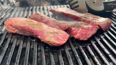 Beef steaks roasting on the grill Stockbeeldmateriaal 312942039