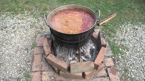 Beef stew boiling in the cast iron pot on the makeshift stove 05 Stock Footage 146543679