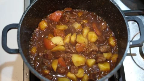 Beef stew boiling in pot on kitchen stove, seamless loop Stock Footage 315740451