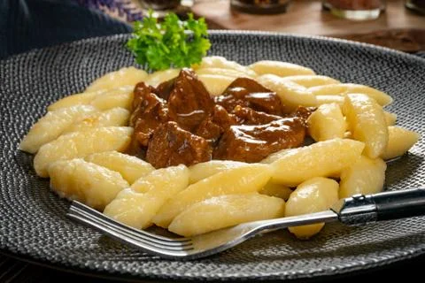 Beef stew in gravy, served with potato dumplings. Stock Photos