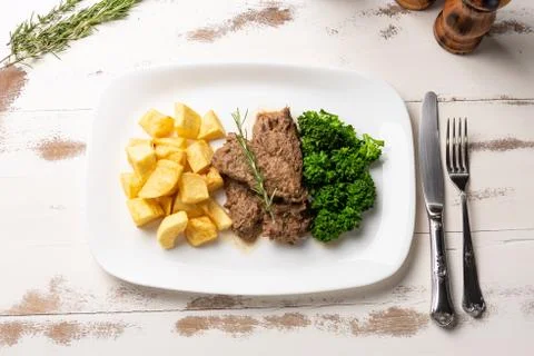 Beef stew with rustic potato and broccoli in a white plate on white wooden ta Stock Photos