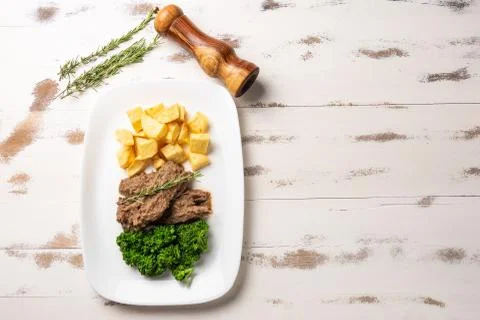 Beef stew with rustic potato and broccoli in a white plate on white wooden ta Stock Photos