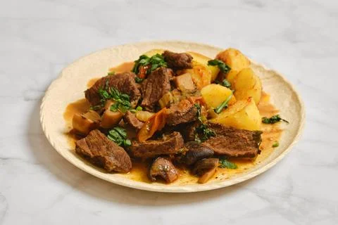 Beef stew served with potatoes and herbs on a plate Foto stock