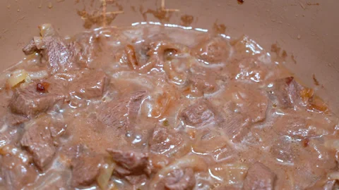 Beef stewed with onions, over low heat Видео 247833119