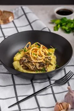 Beef Stroganoff with mashed potatoes and fried onions. Stew with meat. Stock Photos