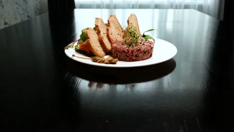 Beef tartar with capers. Beef tartar with slices of bread. Vídeos de archivo 133548728
