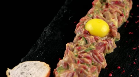 Beef tartare with egg yolk on the black stone board Stock Footage 66482267