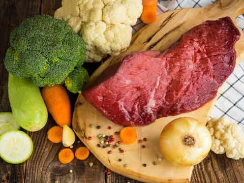 Beef tenderloin and vegetables on rustic wooden background Stock Photos