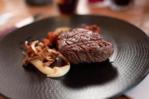 Beef tenderloin with rustic mashed potatoes, roasted cherrys and confit garli Stock Photos