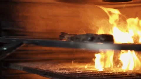 Beef Tomahawk Steak Is Cooking on BBQ Grill. A Cook Turns Up A Steak of Meat Stock Footage 154558221