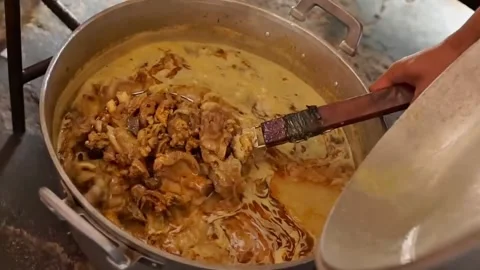 The beef for tongseng is transferred to a large pot Stock Footage 272298732