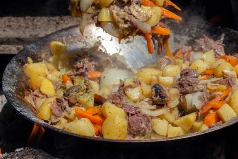 Beef with vegetables cooked in a wok on fire in a mobile kitchen. Stock Photos