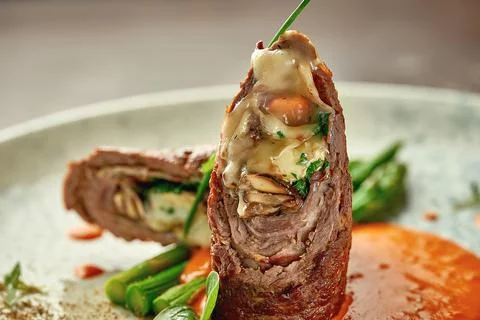 Beef wellington with cheese inside, asparagus and sauce. Close-up. Selective  Stock Photos
