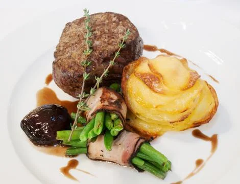Beefsteak with beans in bacon Stock Photos