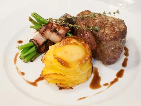 Beefsteak with beans in bacon Stock Photos