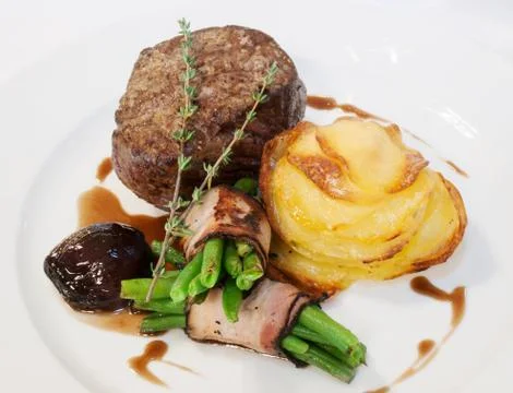 Beefsteak with beans in bacon Stock Photos