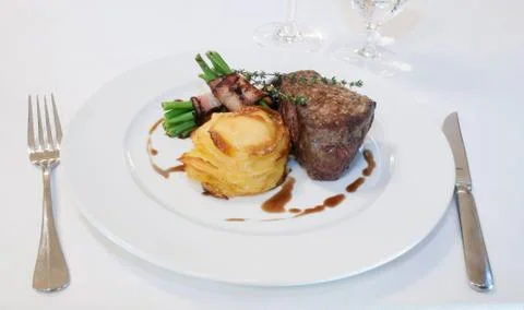 Beefsteak with beans in bacon Stock Photos