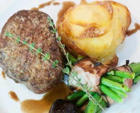 Beefsteak with beans in bacon Stock Photos