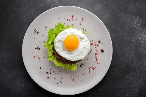 Beefsteak with egg and mashed potatoes on a dark background Stock Photos