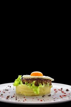 Beefsteak with egg and mashed potatoes on a dark background. vertical Stock Photos