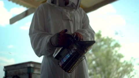 A beekeeper with a bee smoker to neutralize bees in his hands. A man in a 스톡 동영상 204167410