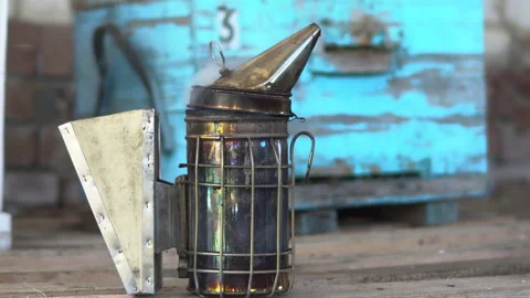 Beekeeper smoke pot stands on the background of the hive. A beekeeper's tool for Stock Footage 136423667