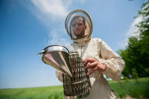 Beekeeper with smoke tool. making clouds Fotos Stock