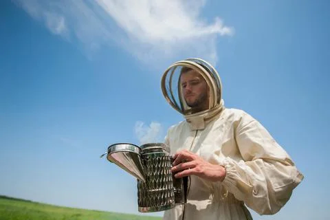 Beekeeper with smoke tool. making clouds Fotos Stock