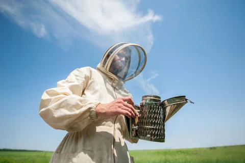 Beekeeper with smoke tool. making clouds Fotos Stock