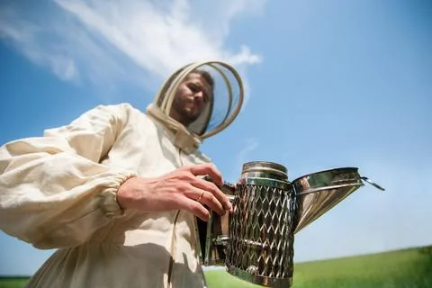 Beekeeper with smoke tool. making clouds Fotos Stock