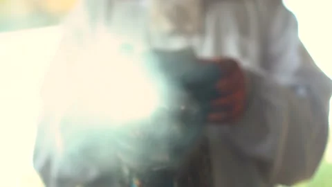 A beekeeper in a suit smokes a smoker into the camera. Smoke to drive the bees Stock-Footage 204937952