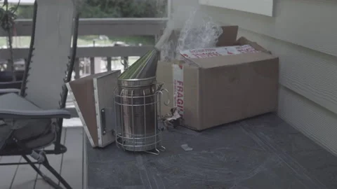 Beekeeping smoker emits smoke while placed on table Stock Footage 134209069