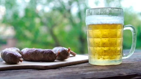 Beer and German sausages outdoors. Octoberfest theme. Slow shooting. Slow motion Stock Footage