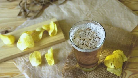 Beer and potato chips on the table. Theme Oktoberfest. Slow motion. a female Stock Footage 80566042