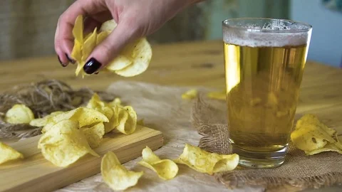 Beer and potato chips on the table. Theme Oktoberfest. Slow motion. a female Stock Footage 81157126