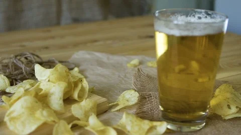 Beer and potato chips on the table. Oktoberfest theme. Slow Motion. Stock Footage 81226900