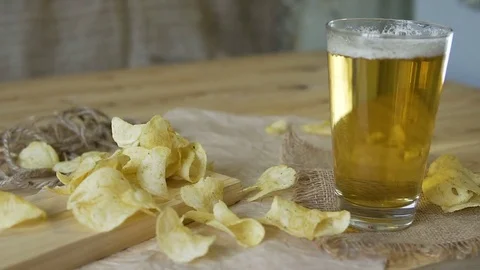 Beer and potato chips on the table. Theme Oktoberfest. Slow motion. a female Stock Footage 81523785