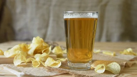 Beer and potato chips on the table. Theme Oktoberfest. Slow motion. a female Stock Footage 81524258