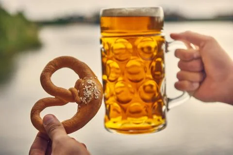 Beer and pretzel in hand, holding pretzel and beer Stock Photos