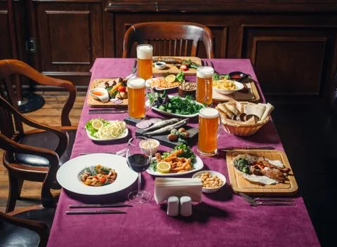 Beer and wine dinner setup with fish, lamb kebab, shrimp Stock Photos
