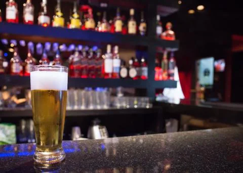 Beer on bar at pub with bottles Stock Photos