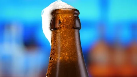 Beer in a beer bottle, forming bubbles and a frothy head. Beer foam flows down Stock Footage 259753614