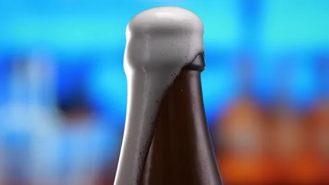 Beer in a beer bottle, forming bubbles and a frothy head. Beer foam flows down Stock Footage 259866944