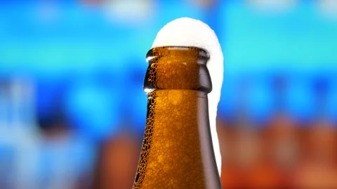 Beer in a beer bottle, forming bubbles and a frothy head. Beer foam flows down Stock Footage 275351405