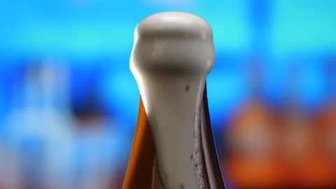 Beer in a beer bottle, forming bubbles and a frothy head. Beer foam flows down Stock Footage 280071768